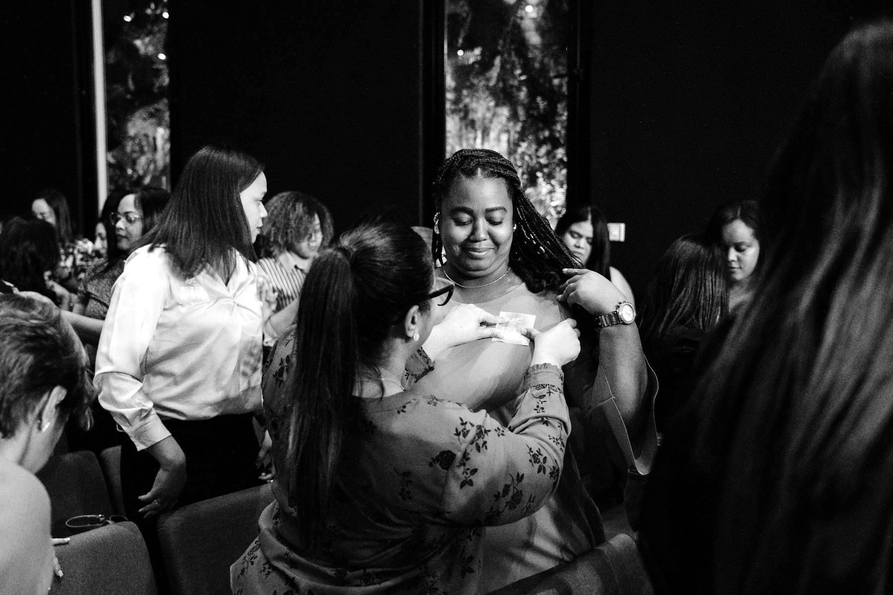 Women greeting each other in a full event hall