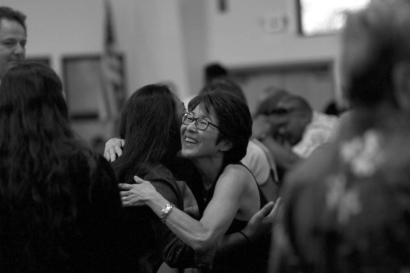Two women hugging at a crowded event